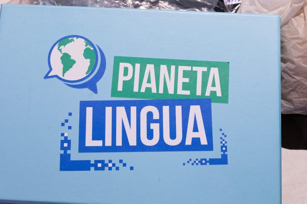 Logo Pianeta Lingua su un pannello durante un evento